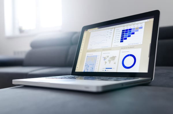 an open laptop with data and charts visible onscreen