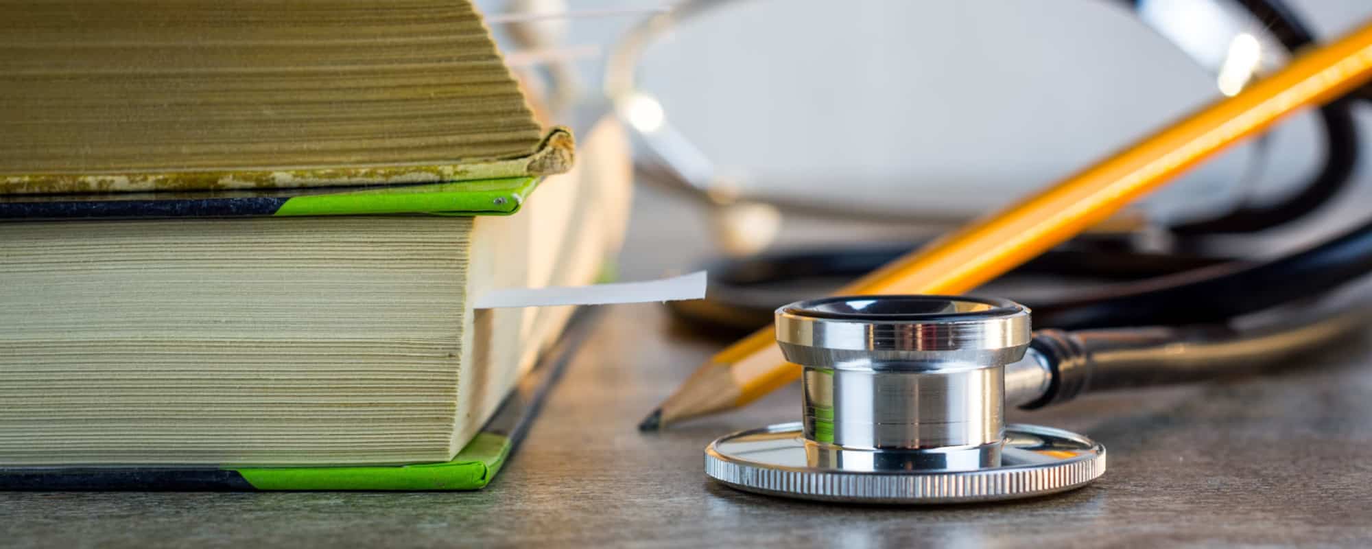 stethoscope, next to a pencil and a stack of books