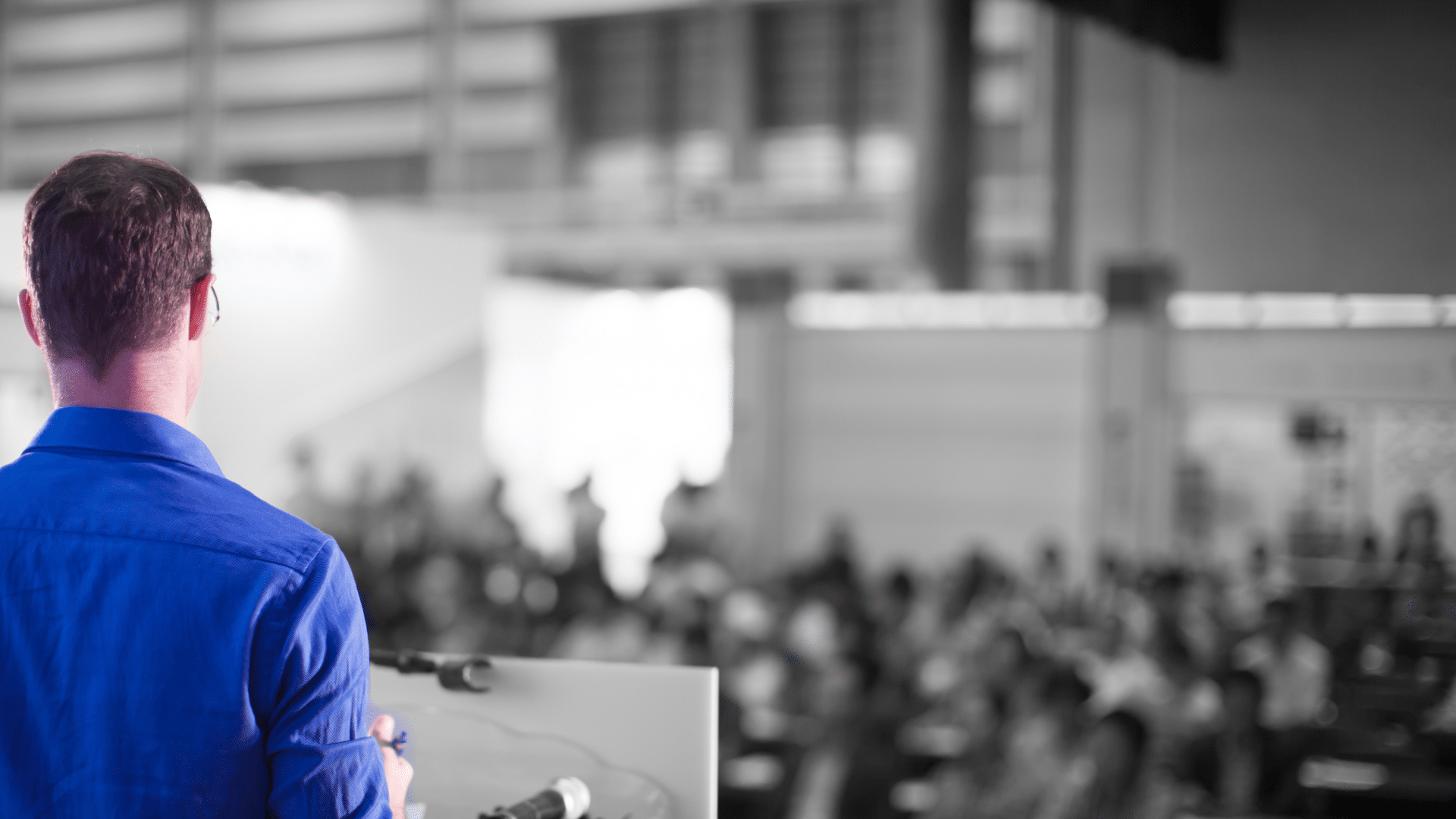 man presenting to a group at a conference